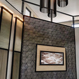 Contemporary interior featuring a wall covered with geometric 3D concrete tiles, a framed artwork, and modern lighting fixtures, creating a stylish and textured design element.