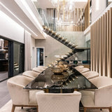 Modern luxury interior with floating staircase, glass railings, and concrete panels interior wall behind dining area