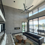 Modern living room with concrete panels, large windows, gray walls, and a view of a lake in chattanooga, United States. -FLOAT Concrete