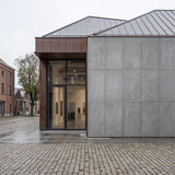 Contemporary art gallery in Antwerp, Belgium, featuring FLOAT KONKRETE XXL lightweight concrete wall panels, with a minimalist architectural façade, large glass entrance and contrasting weathered metal cladding.