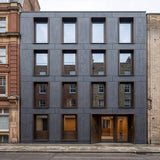 Modern commercial building in London clad in FLOAT KONKRETE XXL lightweight concrete wall panels in Gunmetal colour, featuring a contemporary façade with large recessed windows and precision architectural detailing. - FLOAT concrete